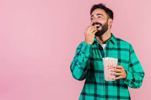 Photo medium shot happy guy eating popcorn