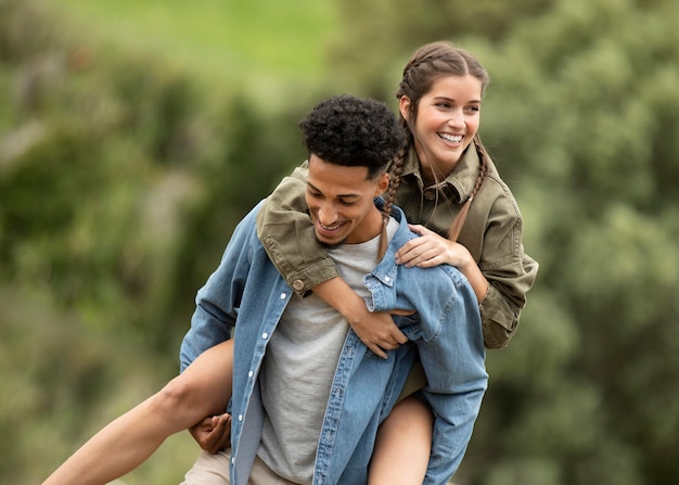 Foto uomo felice del colpo medio che trasporta donna