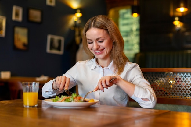 Foto donna felice del colpo medio che mangia