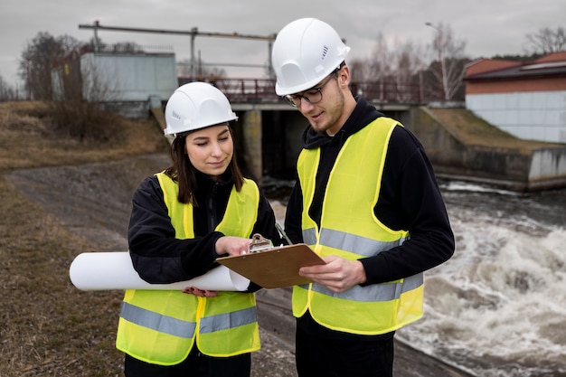 Foto medium shot ingenieurs die een veiligheidshelm dragen