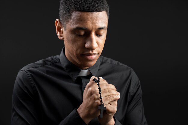 Medium shot jonge priester aan het bidden