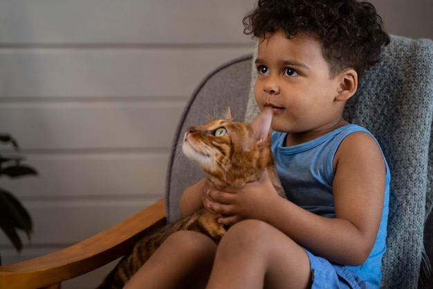 写真 かわいい猫を抱いたミディアムショットの子供