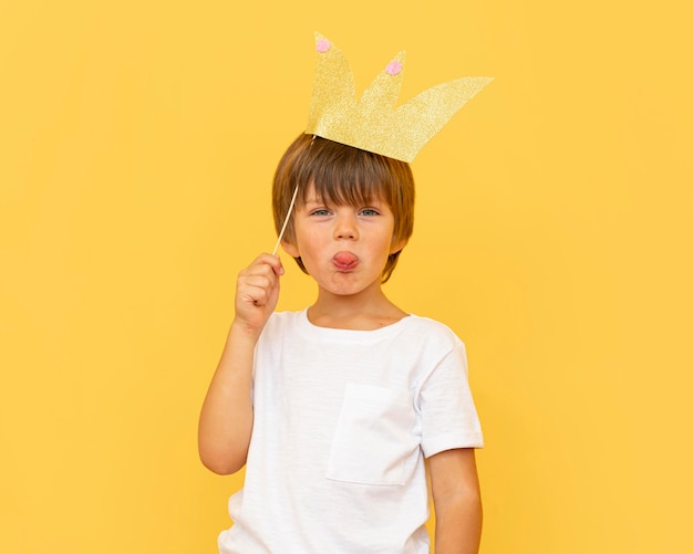 Средний выстрел ребенок держит бумажную корону