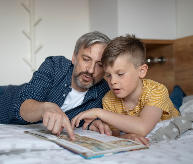 Medium shot kid and man reading