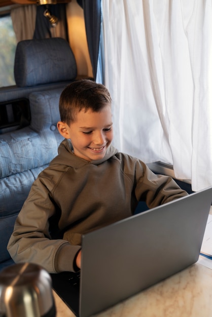 Foto ragazzo di tiro medio che gioca sul laptop