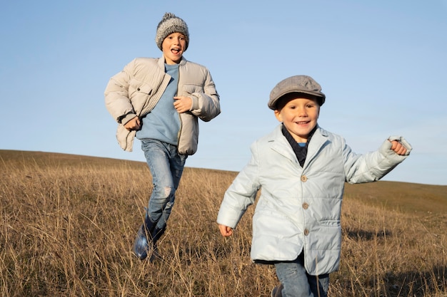 Photo medium shot kids running on field