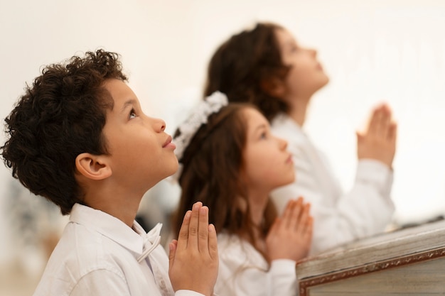 Photo medium shot latin kids making communion