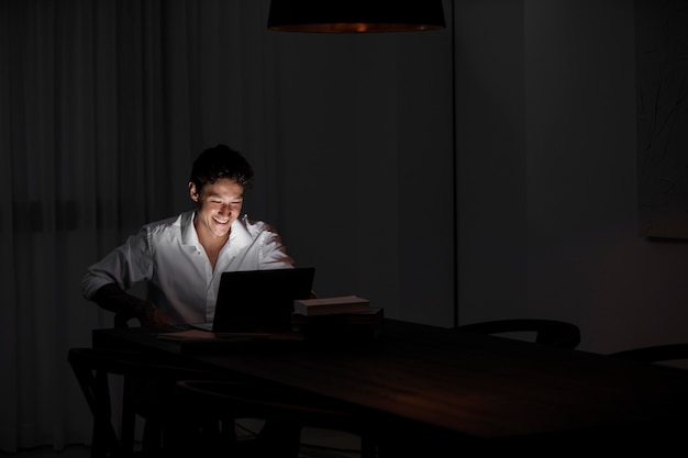 Foto medium shot man die 's nachts op laptop werkt