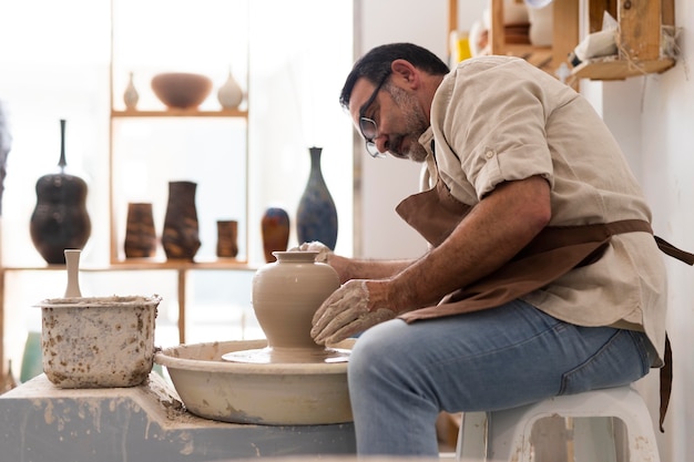 Uomo di tiro medio che fa ceramica all'interno