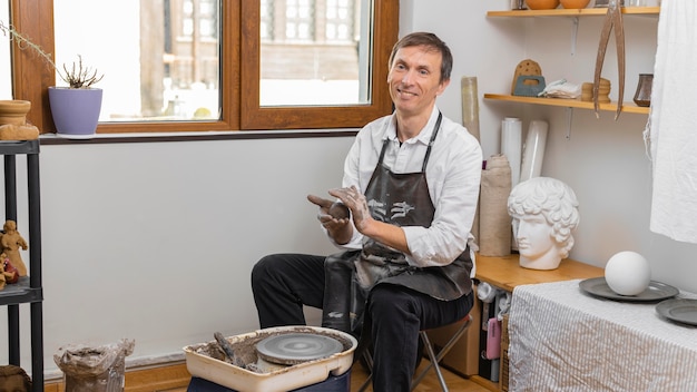 Medium shot man doing pottery