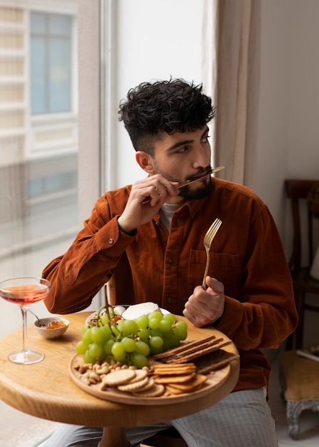 Medium shot man eating fresh cheese