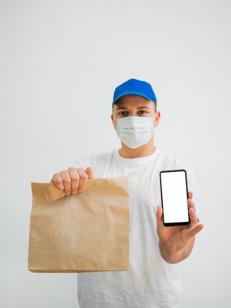 Foto borsa e telefono della tenuta dell'uomo del colpo medio