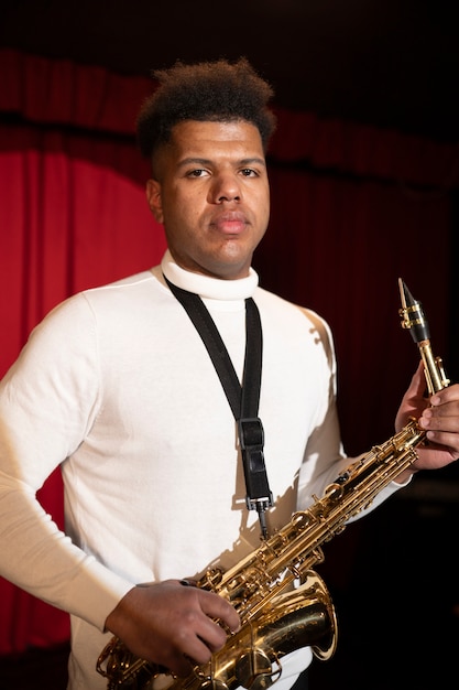 Medium shot man holding saxophone