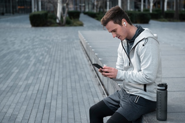 Photo medium shot man holding smartphone