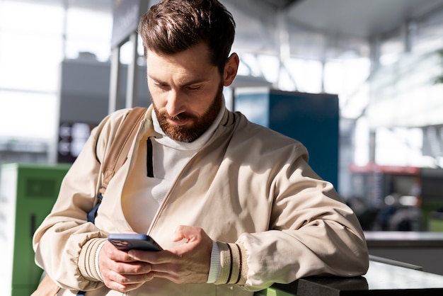 スマートフォンを持っているミディアムショットの男