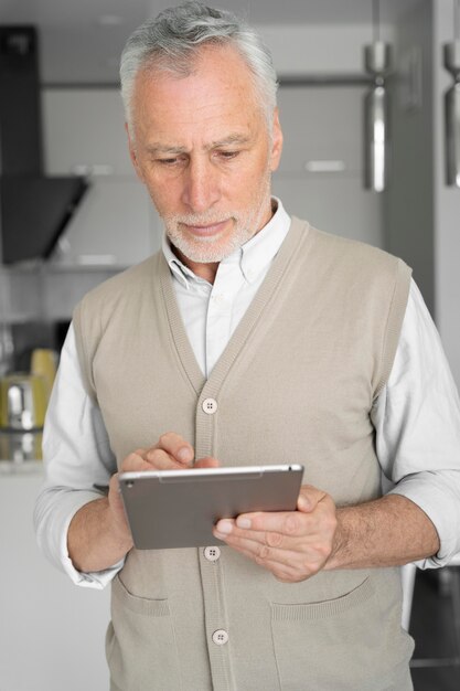 Foto uomo con colpo medio che tiene tablet