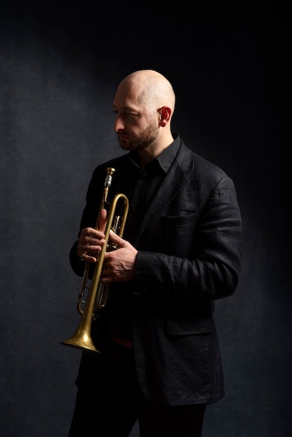 Medium shot man holding trumpet indoors