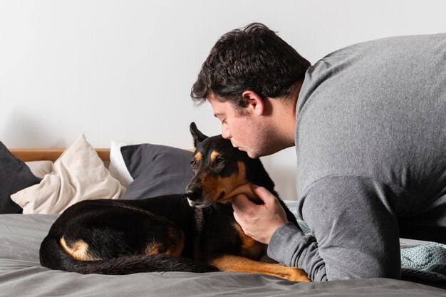 ミディアムショットの男が犬にキス