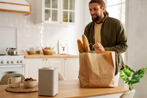 Foto medium shot man met boodschappen thuis