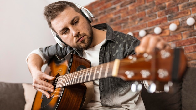 Medium shot man playing the guitar