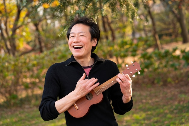 Medium shot man playing ukulele