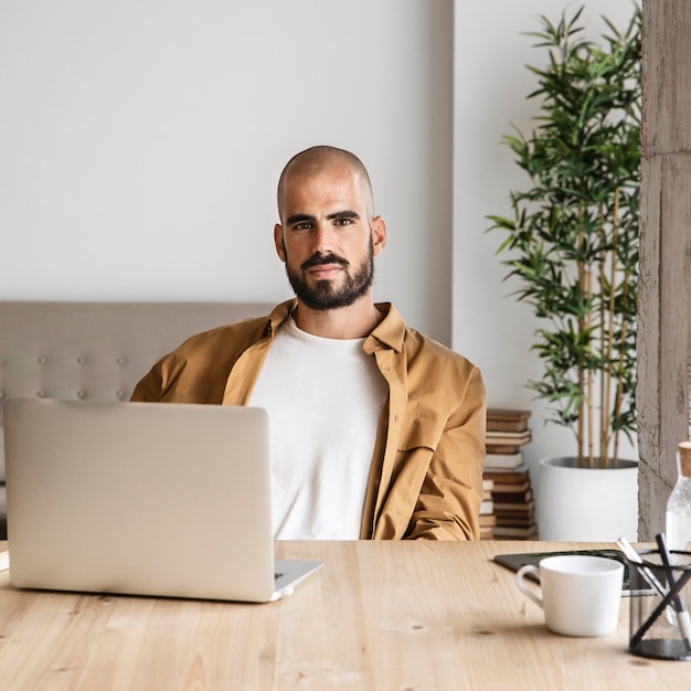 Medium shot man posing with laptop