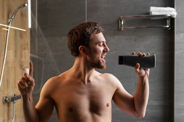 Foto uomo del piano medio che canta sotto la doccia