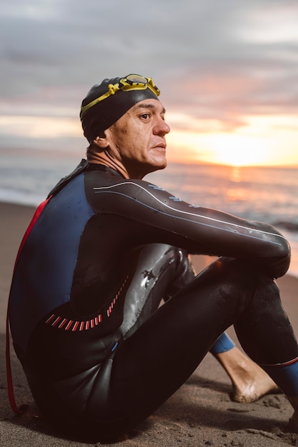 Medium shot man sitting on beach