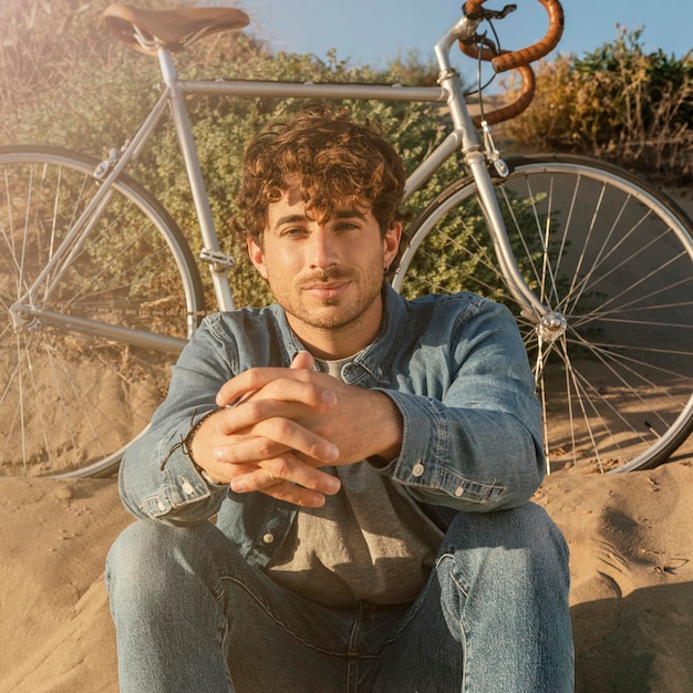 Medium shot man sitting on sand