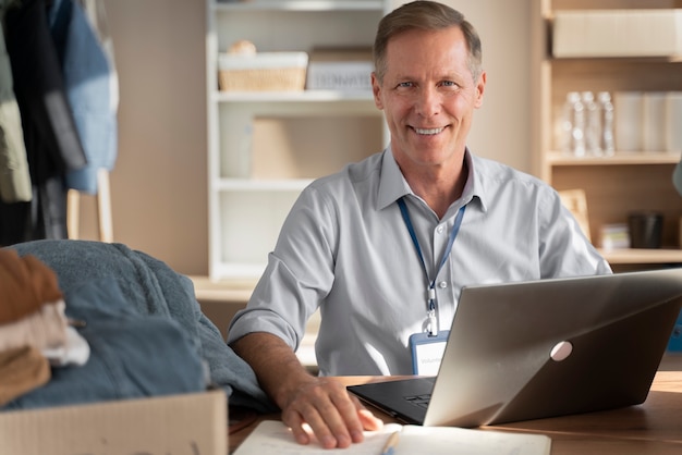 Photo medium shot man sitting with laptop