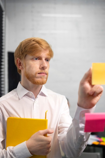 Photo medium shot man sticking post it on window