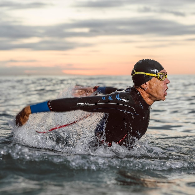 Foto vista laterale di nuoto dell'uomo del colpo medio