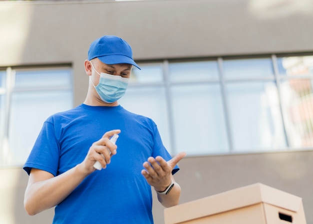 Foto uomo di tiro medio che utilizza disinfettante