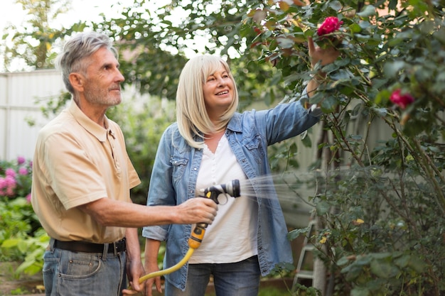 Photo medium shot man watering flowers