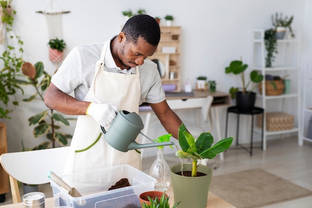 Photo medium shot man watering plant at home