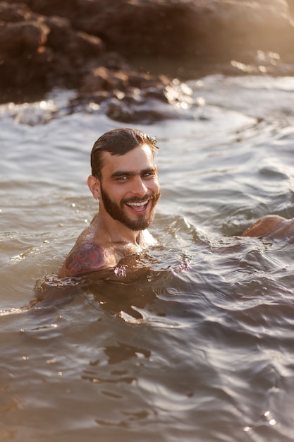 Medium shot man with hairy chest at seaside