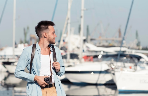 写真 古いカメラを持つミディアムショットの男