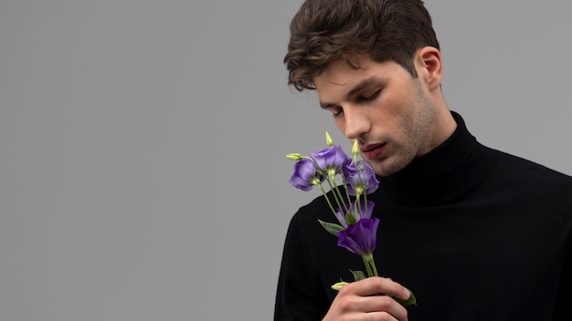 紫色の花を持つミディアムショットの男