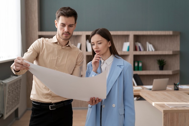 Foto uomo e donna di tiro medio che lavorano