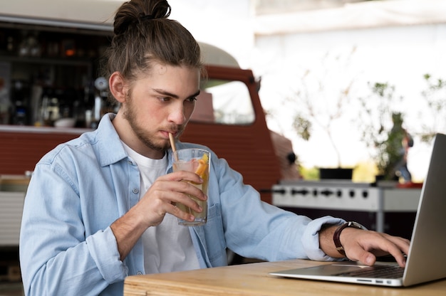 Uomo del tiro medio che lavora al computer portatile