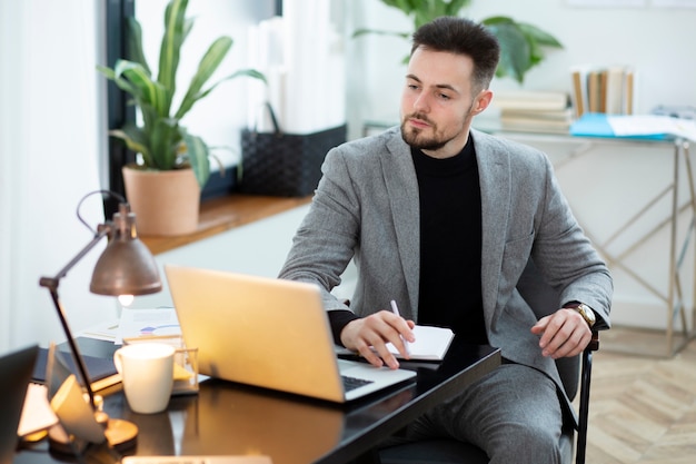 Medium shot man working with laptop