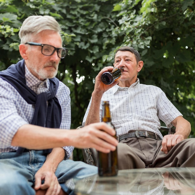 Uomini di tiro medio che bevono birra