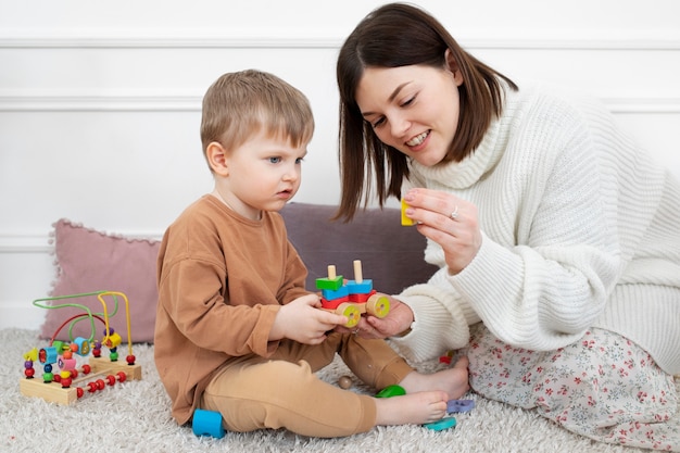 Foto medium shot moeder en kind met educatief spel