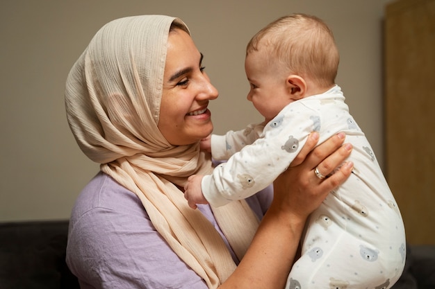 Bambino della holding della madre del colpo medio