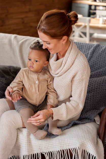 medium shot mother holding kid on couch