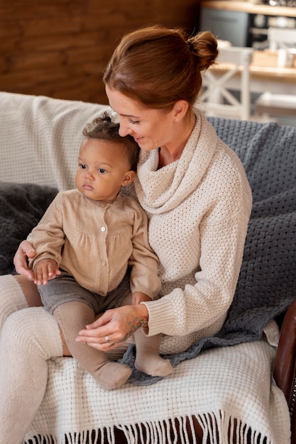 Medium shot mother holding kid on couch