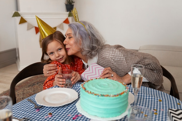 Medium shot old woman and girl celebrating birthday