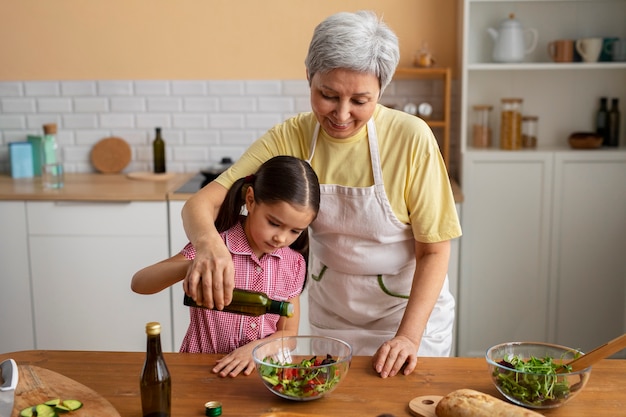 Medium shot oma en meisje die samen koken