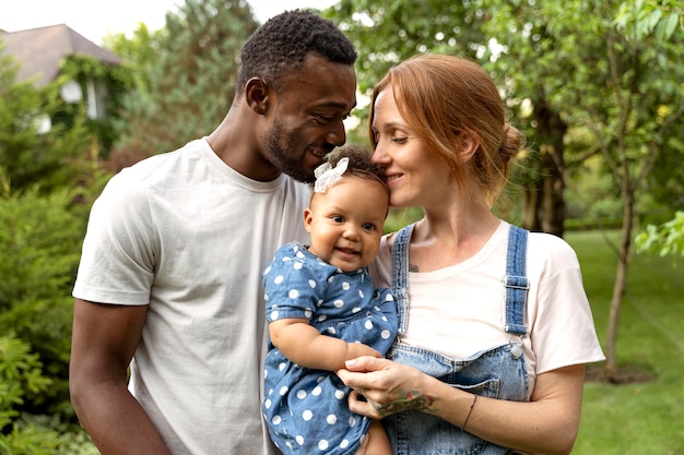 Photo medium shot parents holding cute baby