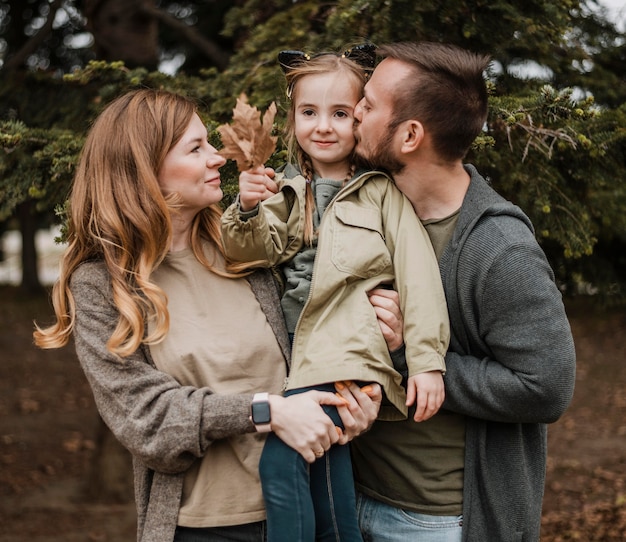 medium shot parents holding daughter